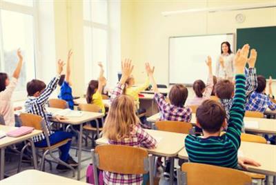 group-of-school-kids-with-teacher-sitting-in-classroom-and-raising-hands.jpg